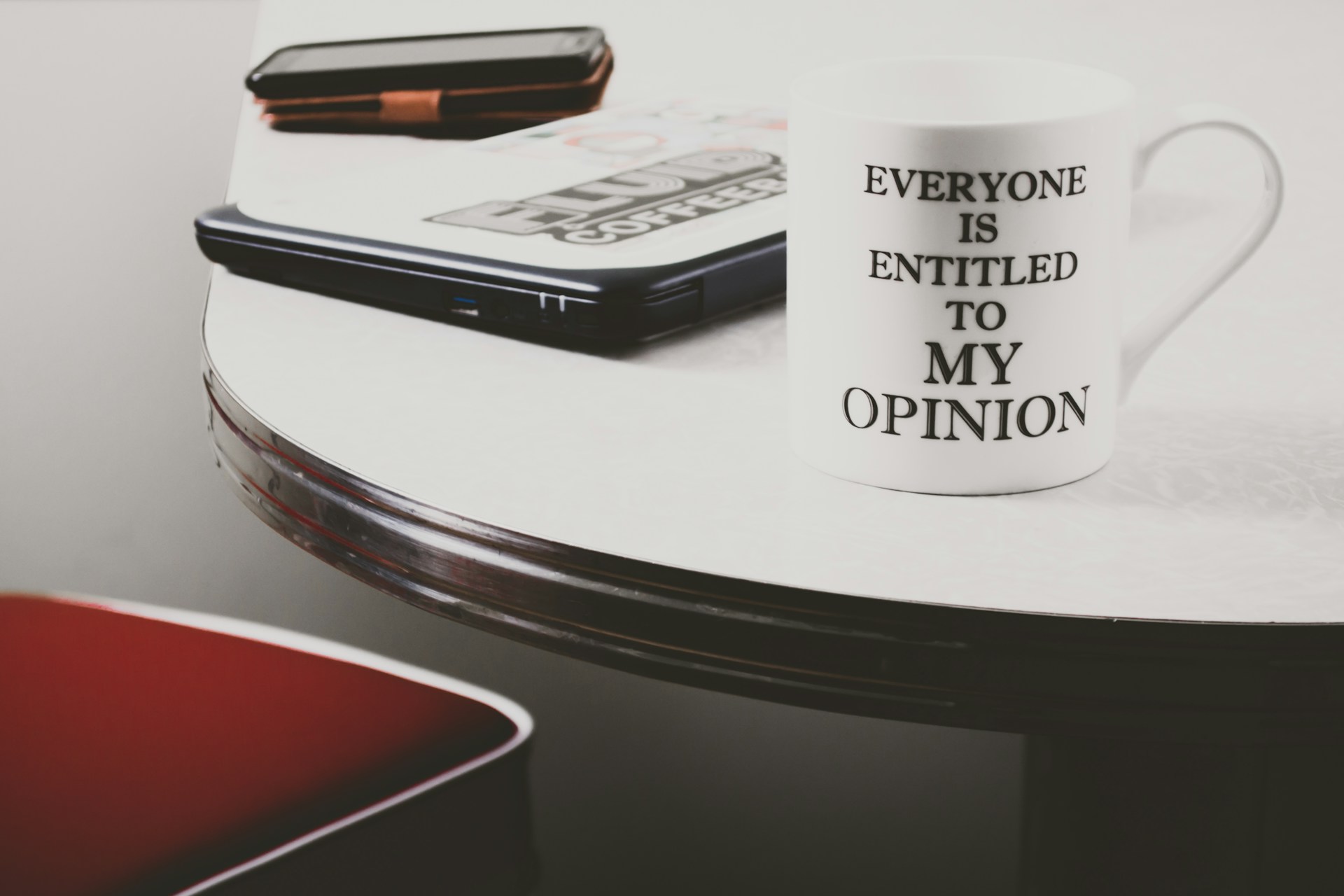Tasse of einem Bürotisch mit der Aufschrift “Everyone is entitled to my opinion”