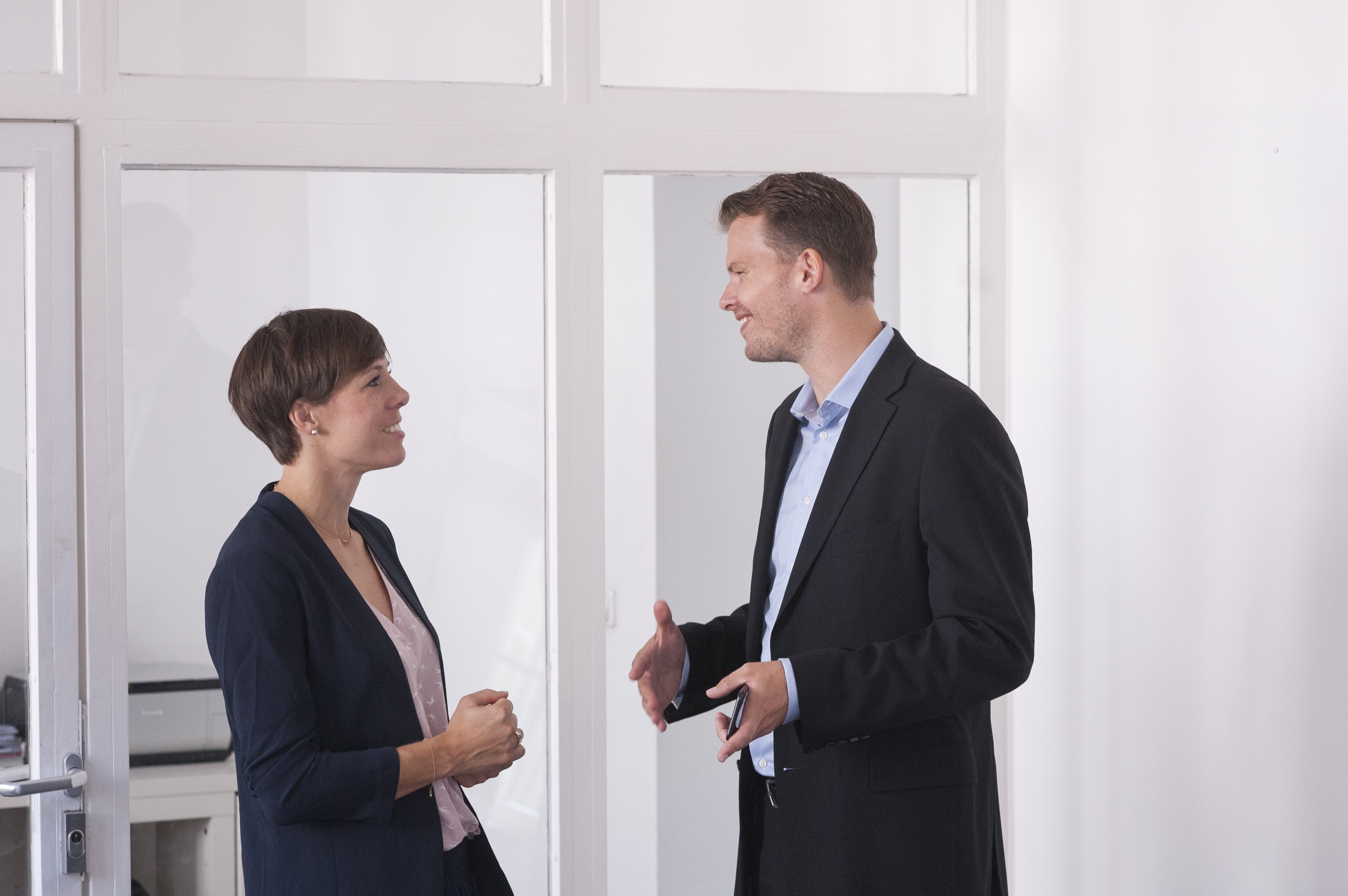 Two persons talking in office standing
